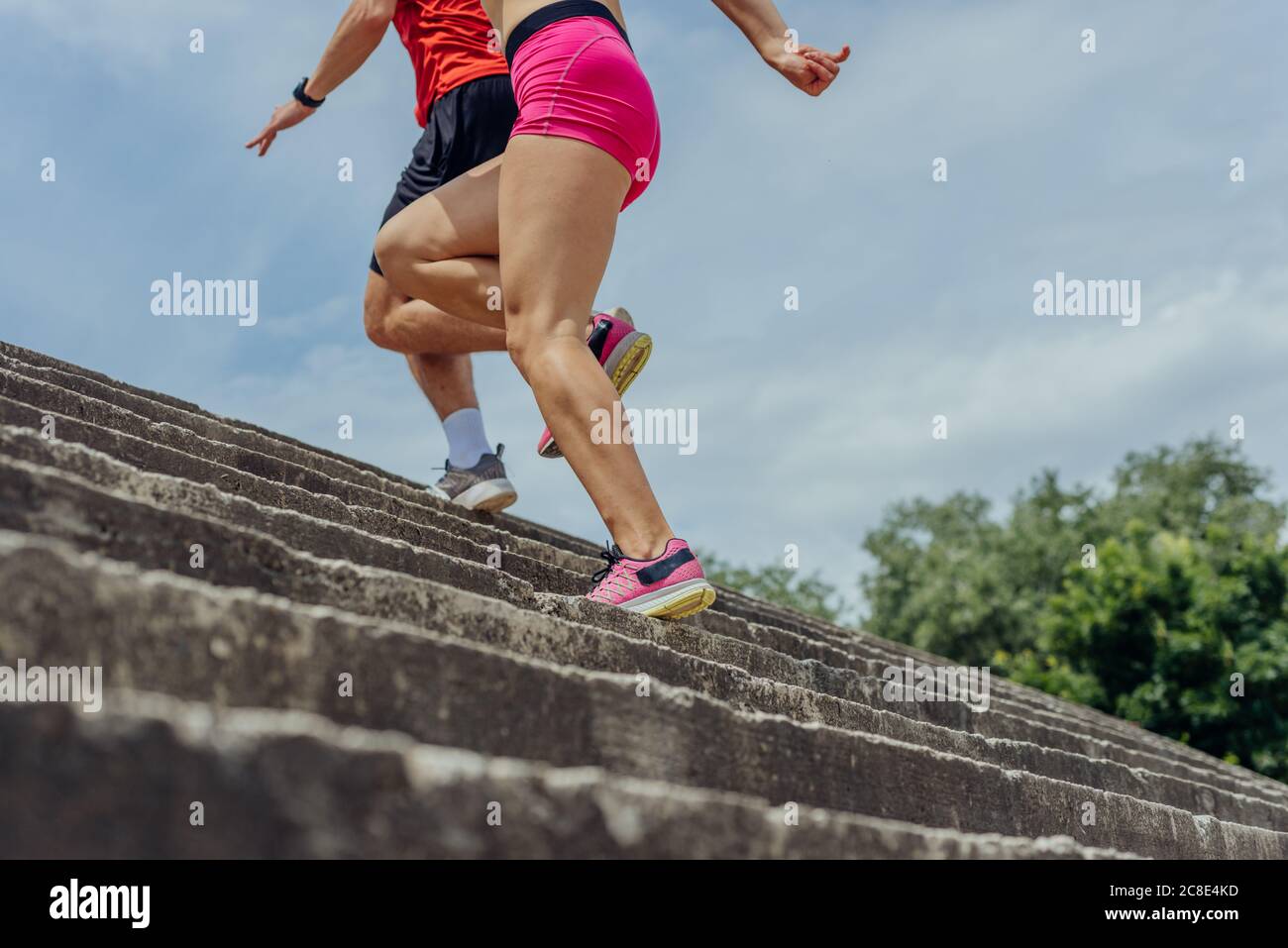 De cerca y bajo ángulo ver foto de atletas piernas corriendo por escaleras de hormigón Foto de stock