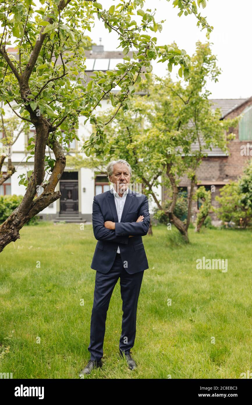 Hombre de negocios de alto nivel confiado en un jardín rural Foto de stock