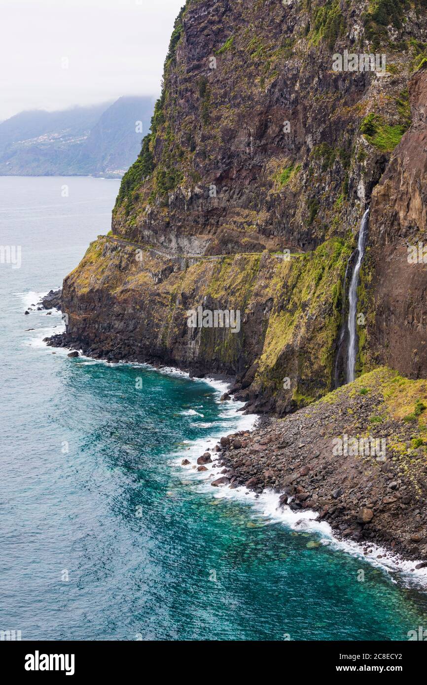 Portugal, Porto Moniz, Veu da Noiva cascada salpicando el acantilado costero de la isla de Madeira Foto de stock