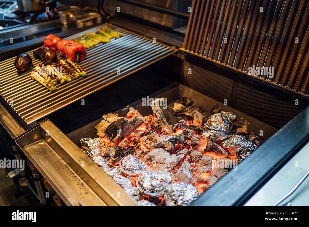 Carbón y verduras a la parrilla en la cocina del restaurante Foto de stock