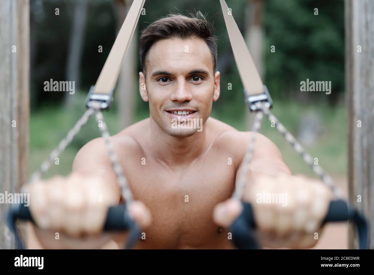 Hombre durante el entrenamiento con cuerda en el bosque Foto de stock