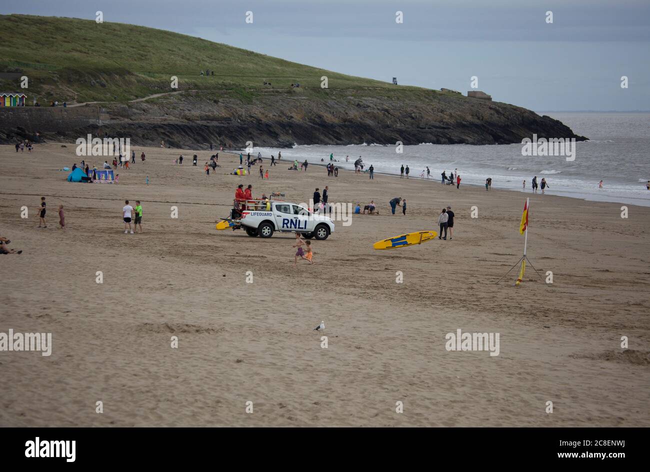 RNLI trabajando en una playa de verano muy concurrida, camión patrulla, salvavidas, playa familiar, arena, olas, Cymru, Foto de stock