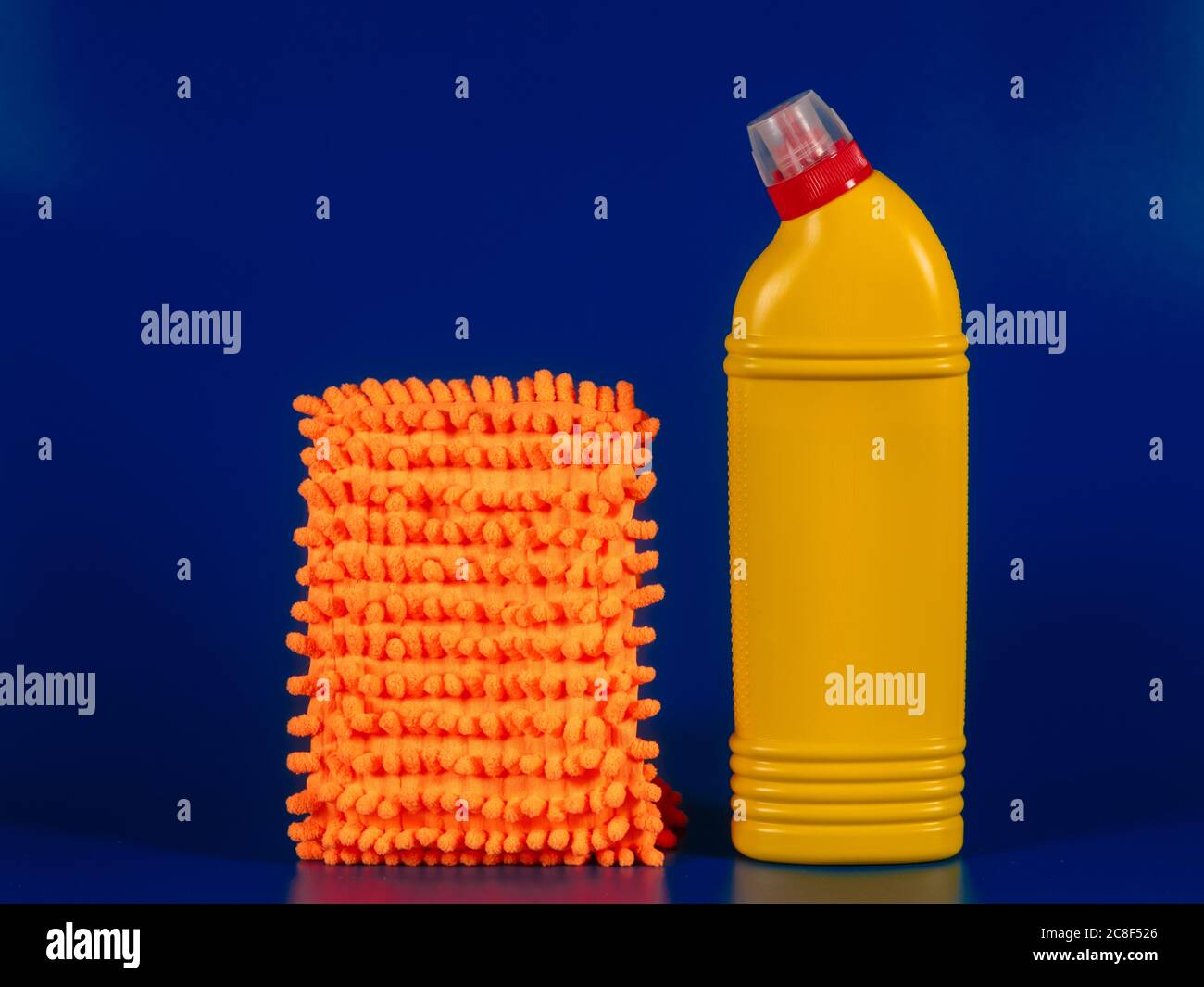 mopa de tela y botella amarilla con agente de lectura sobre fondo azul  Fotografía de stock - Alamy