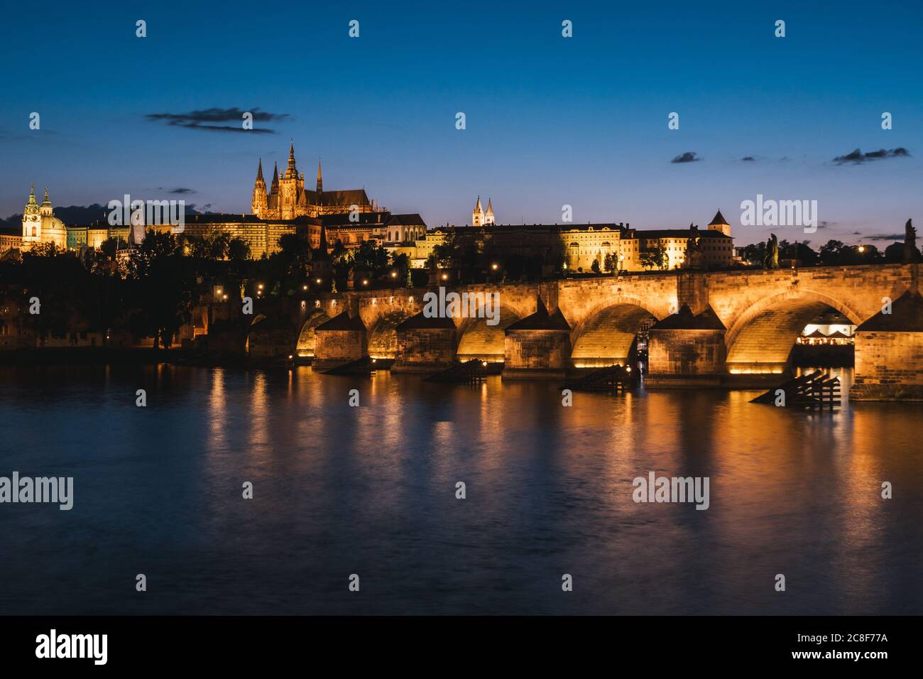 Puente de Carlos en Praga por la noche cruzando el río Vltava con la Catedral de San Vito y el paisaje del Castillo de Praga Foto de stock