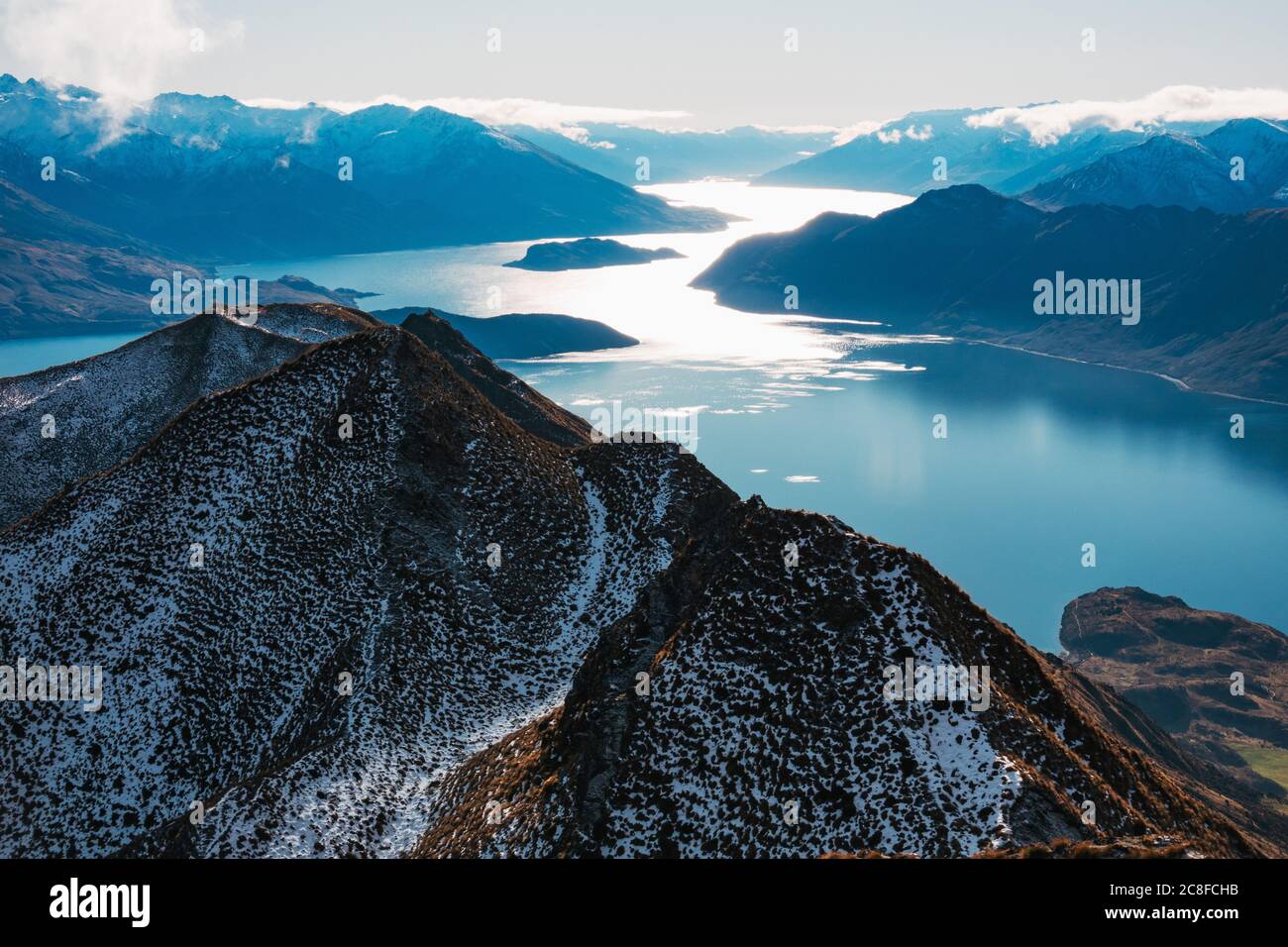 La luz del sol refleja el agua del lago Wanaka, vista desde Roys Peak, Nueva Zelanda Foto de stock