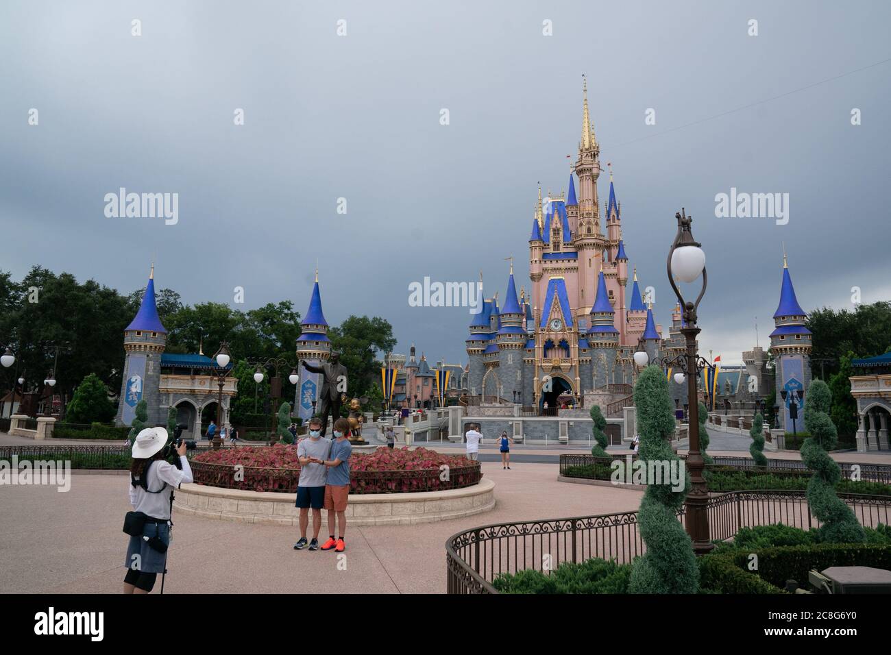 Orlando, FLA, . 23 de julio de 2020. La gente es fotografiada frente a  un castillo de Cenicienta, en su mayoría vacío, en el Reino Mágico de Walt  Disney World el 23
