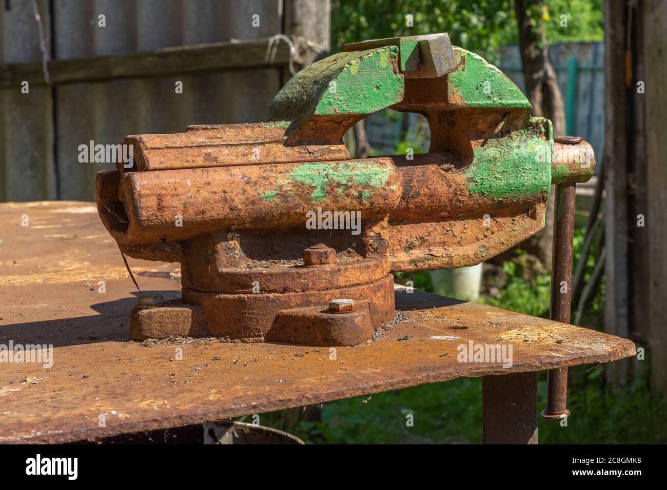 La antigua herramienta de metal de hierro de la mordaza de acero oxidado en  el banco de trabajo del taller en vista lateral de día Fotografía de stock  - Alamy