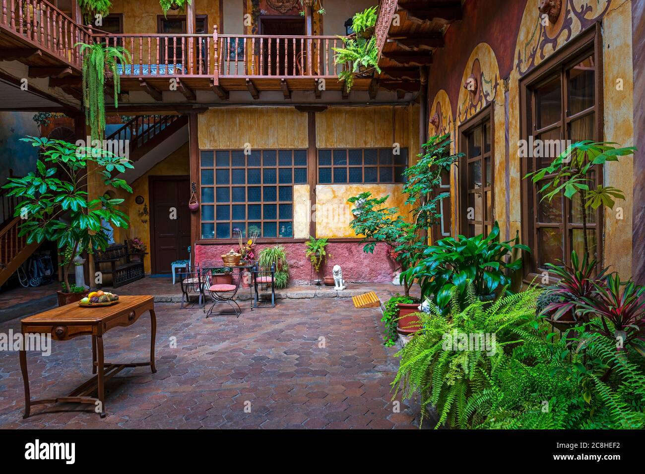 Arquitectura de estilo colonial de un patio interior en Cuenca, Ecuador. Concéntrate en la pared de la parte trasera. Foto de stock