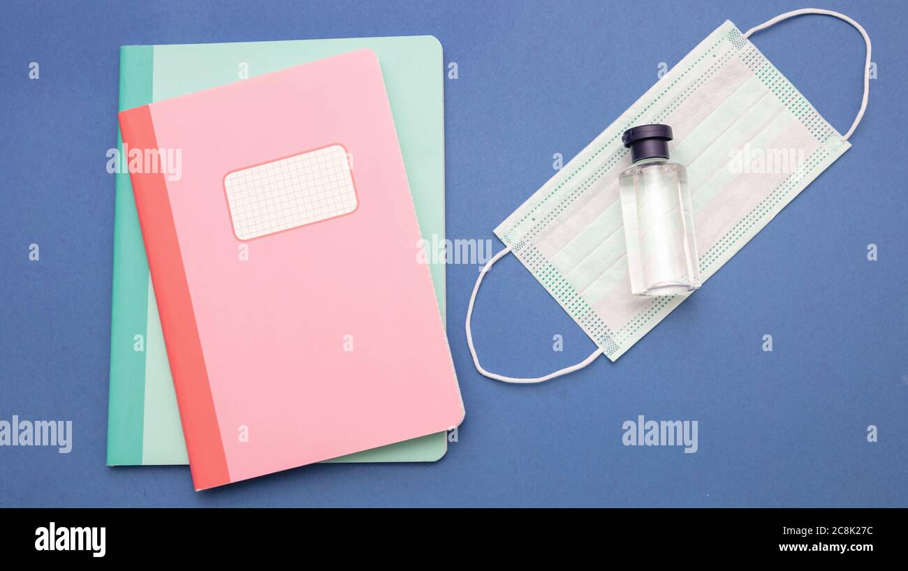 De vuelta a la escuela, días de coronavirus. Máscara protectora médica, gel  desinfectante para manos y materiales escolares sobre fondo color verde  pastel, vista superior, plantilla Fotografía de stock - Alamy