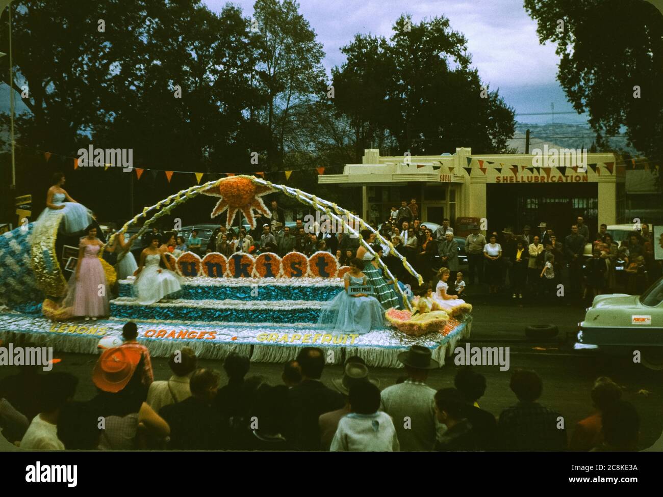 El flotador Sunkist se tira de una gasolinera Shell durante el desfile del día de los Veteranos en Porterville, California en noviembre de 1954. Foto de stock