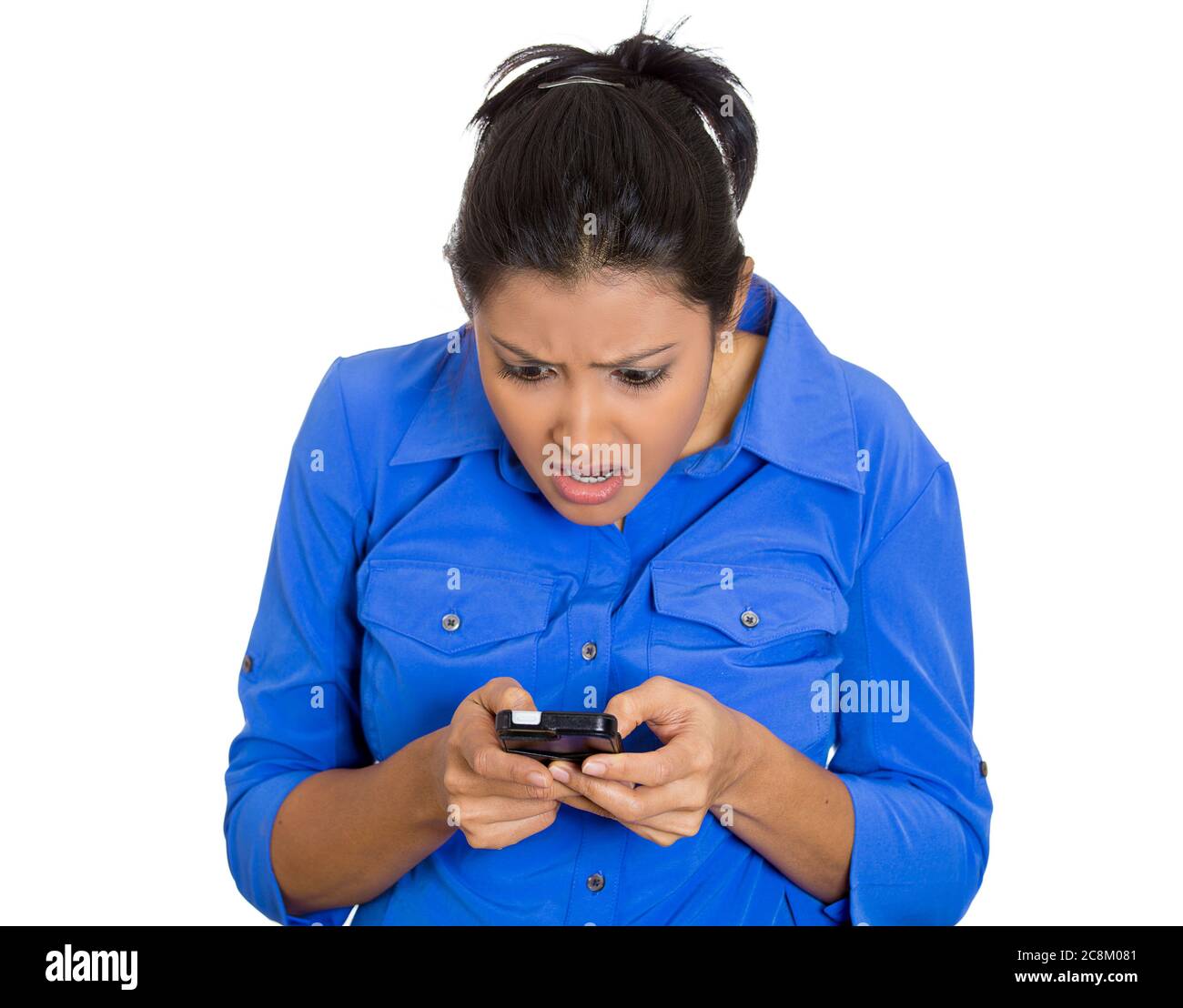 Retrato de una joven, mujer conmocionada que escribe en el teléfono celular viendo un mensaje malo, correo electrónico aislado sobre fondo blanco. Foto de stock
