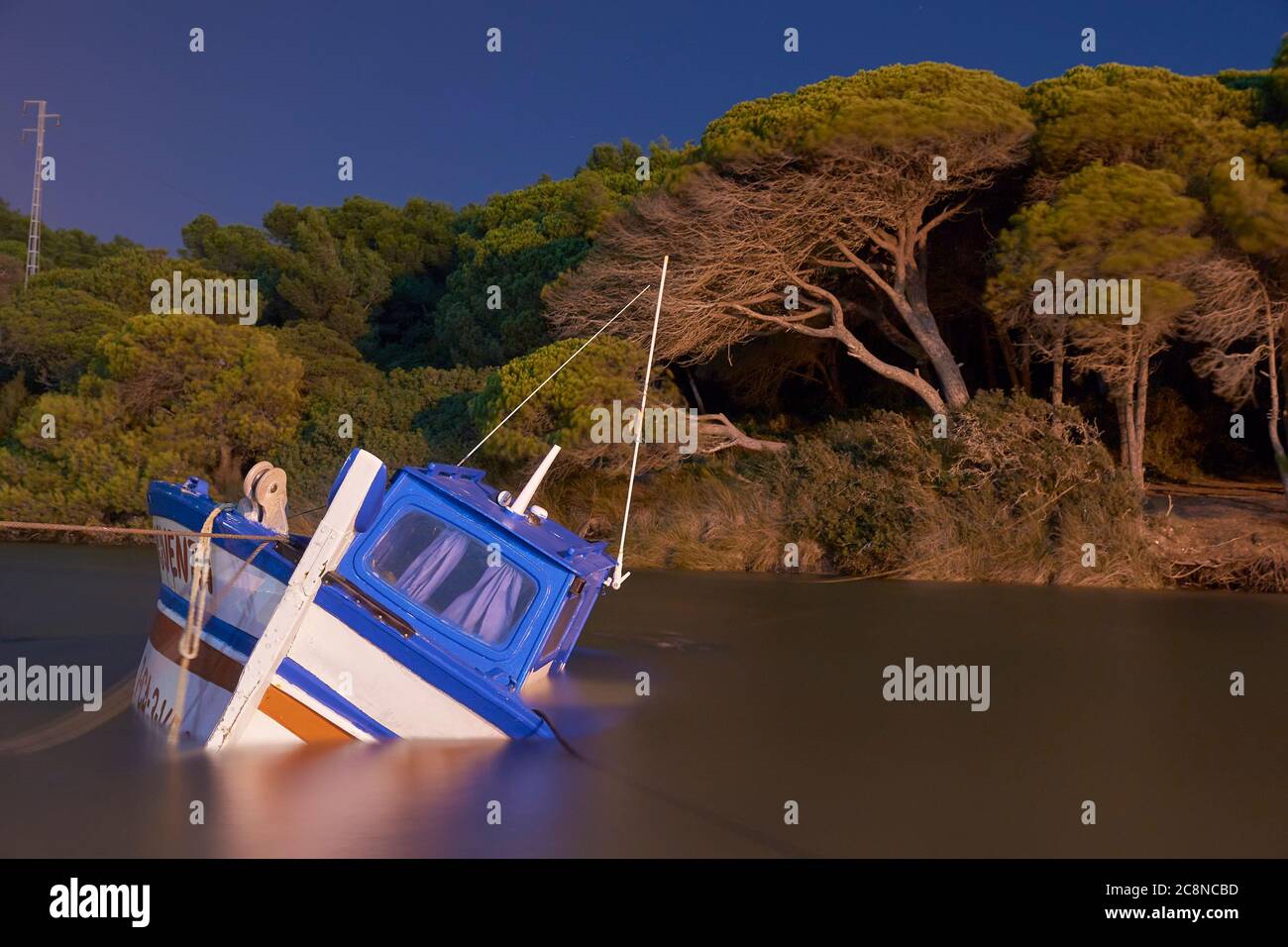 Escena nocturna de un barco de pesca abandonado y hundido en la costa de Cádiz. Andalucía, España Foto de stock