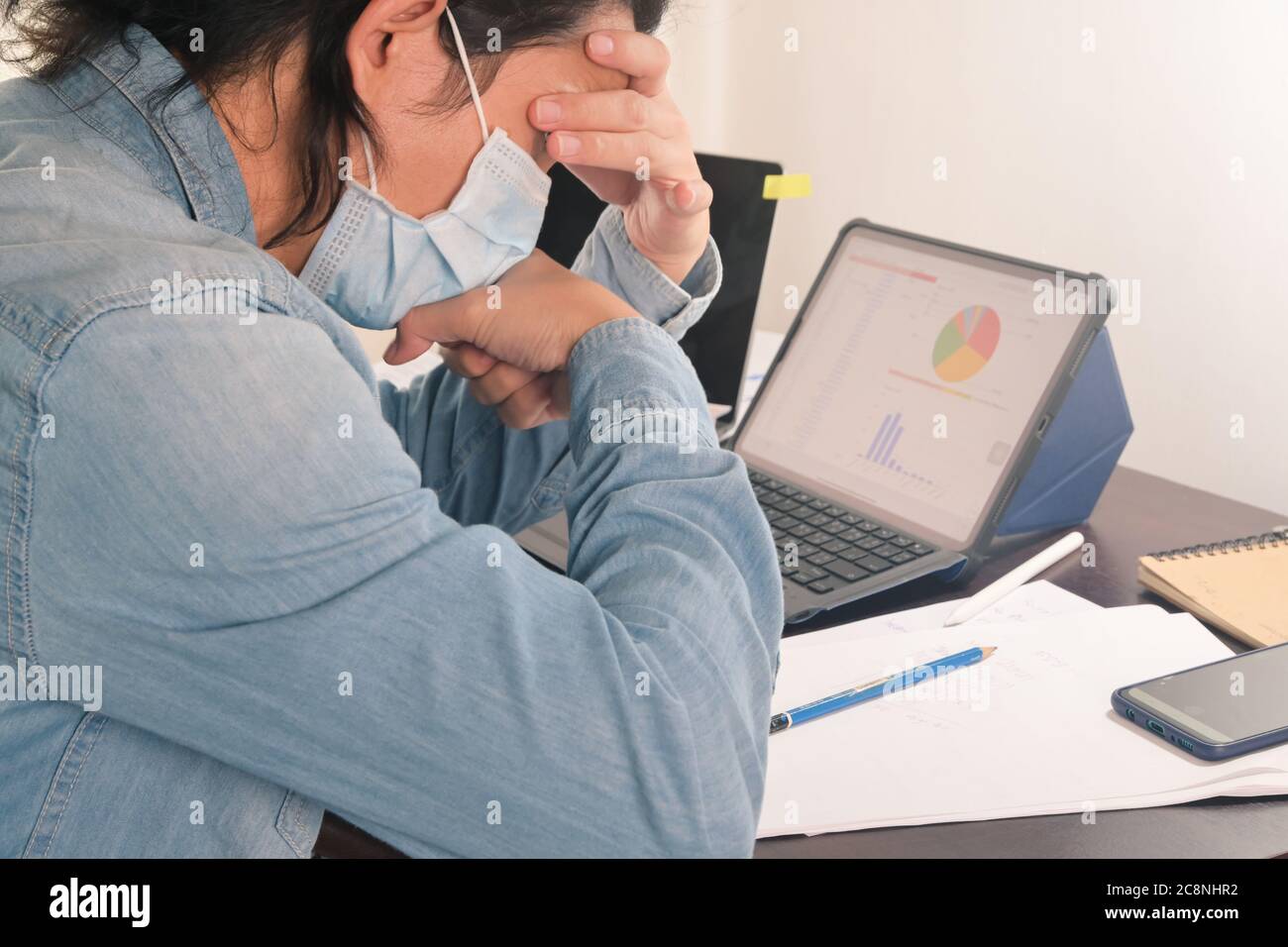 El hombre de negocios tiene dolor de cabeza y tos trabajará con documentos y tabletas digitales en la oficina en casa hacer que el negocio de inicio informe después de coronavirus Foto de stock
