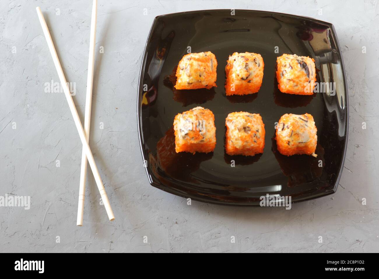 Sushi japonés con palillos sobre fondo de hormigón gris. Vista superior Foto de stock
