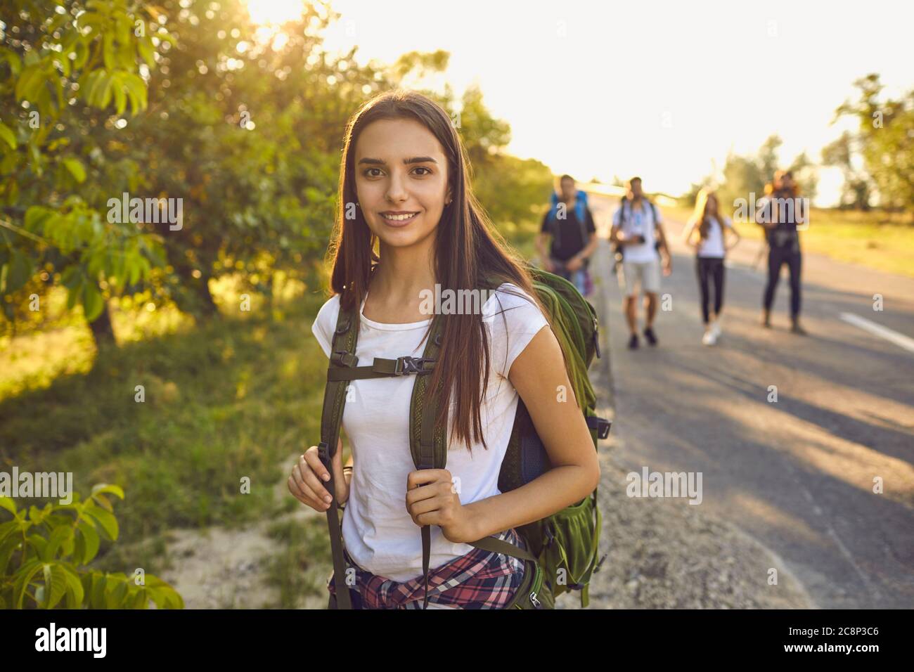 Una chica con mochila sonríe en una excursión en un viaje por la naturaleza. Senderismo Foto de stock
