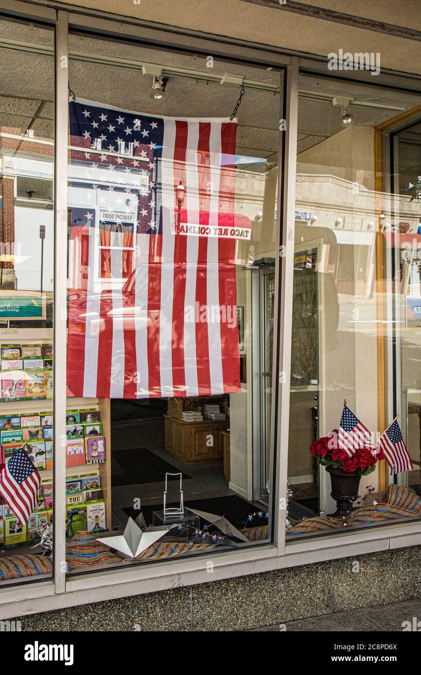 Una bandera americana cuelga en una ventana de la tienda en Gardner, Massachusetts Foto de stock