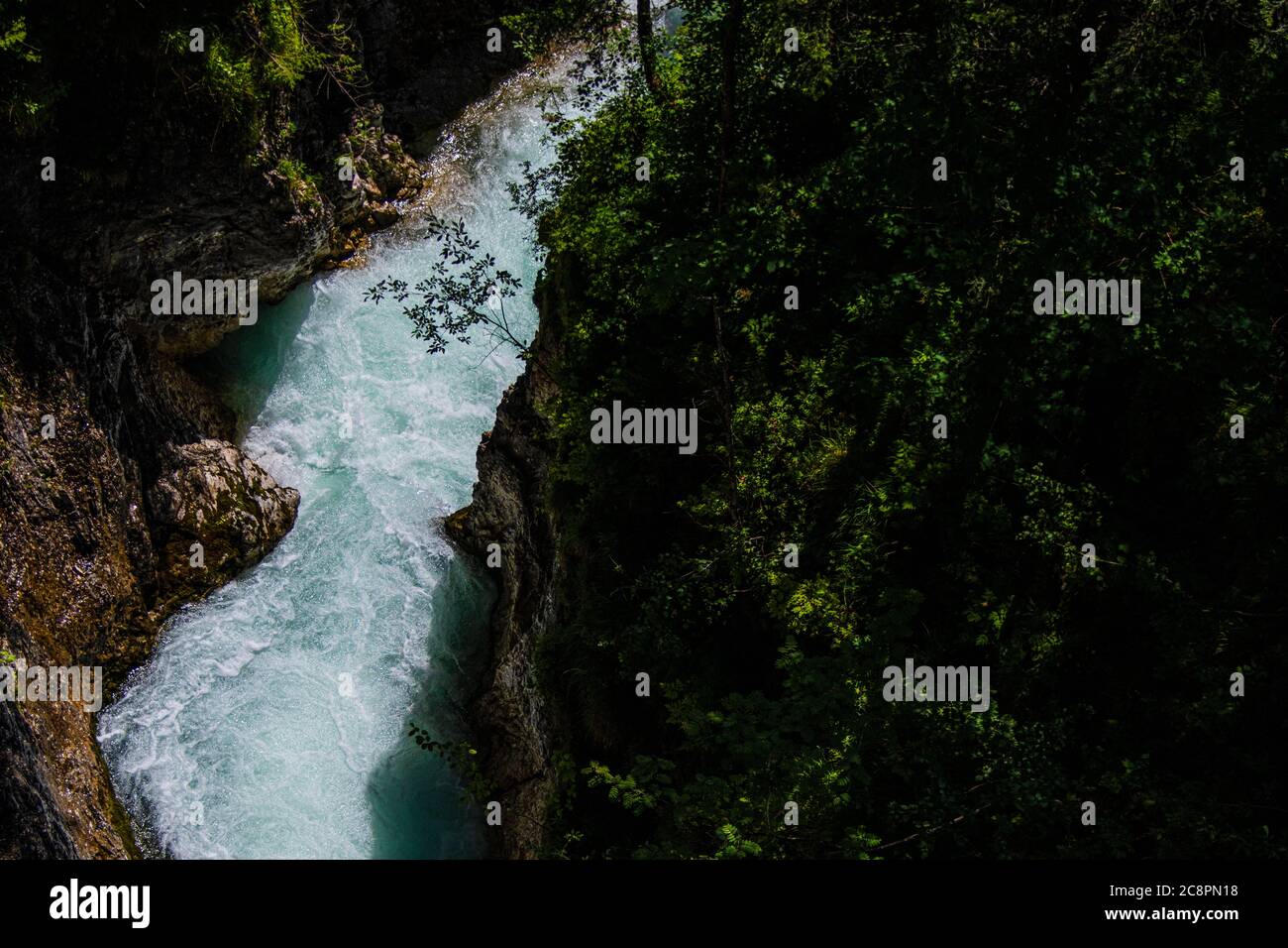 El agua azul del río que cruza el paisaje de montaña entre el bosque verde Foto de stock