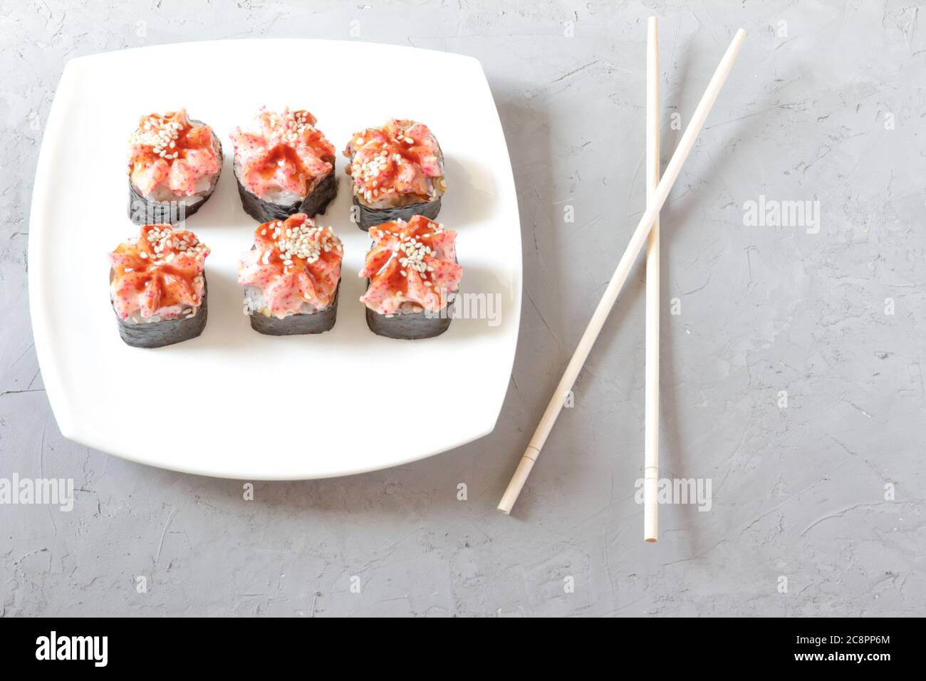 Sushi japonés con palillos sobre fondo de hormigón gris. Vista superior Foto de stock