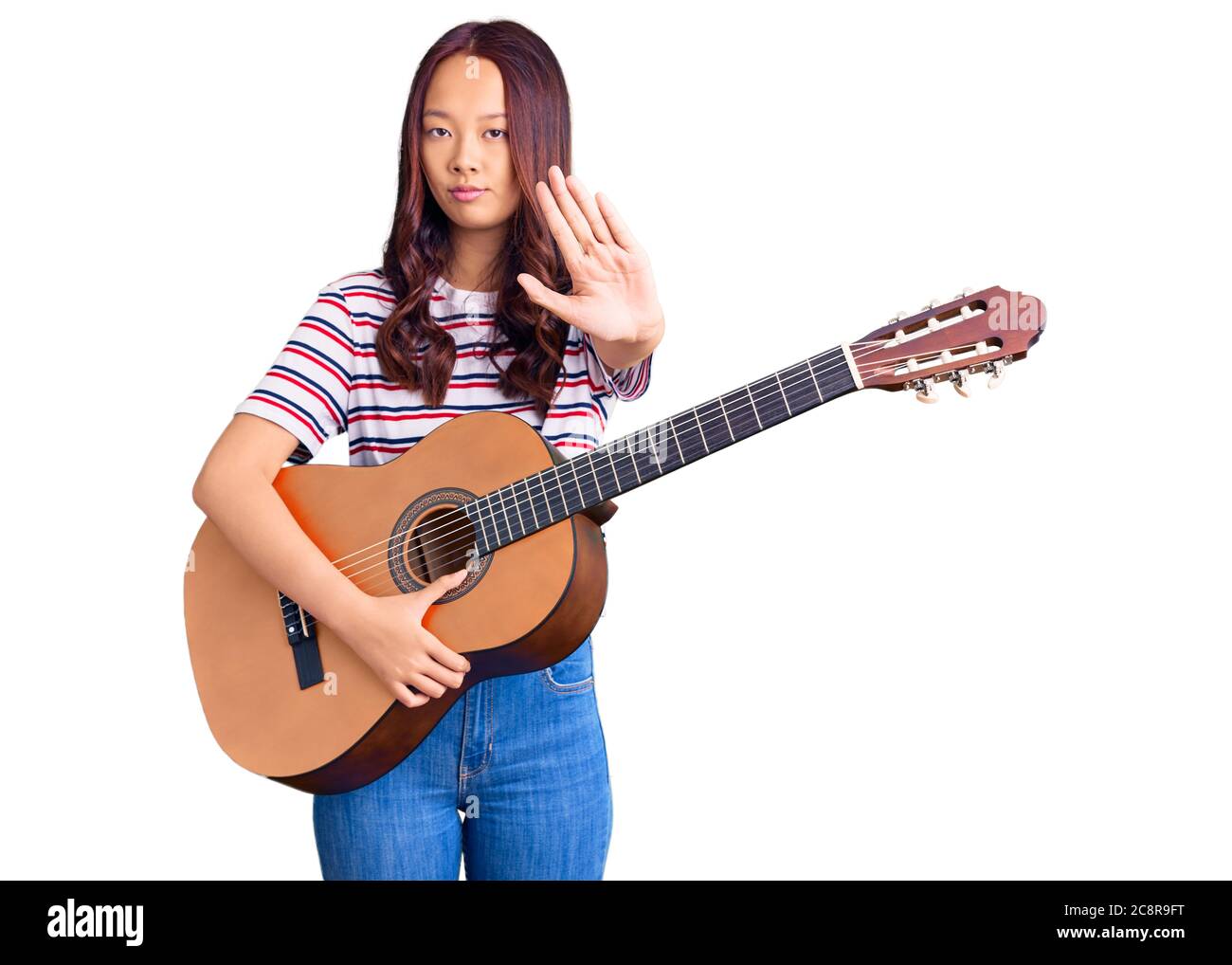 Joven hermosa chica china tocando guitarra clásica con mano abierta  haciendo stop con expresión seria y segura, gesto de defensa Fotografía de  stock - Alamy