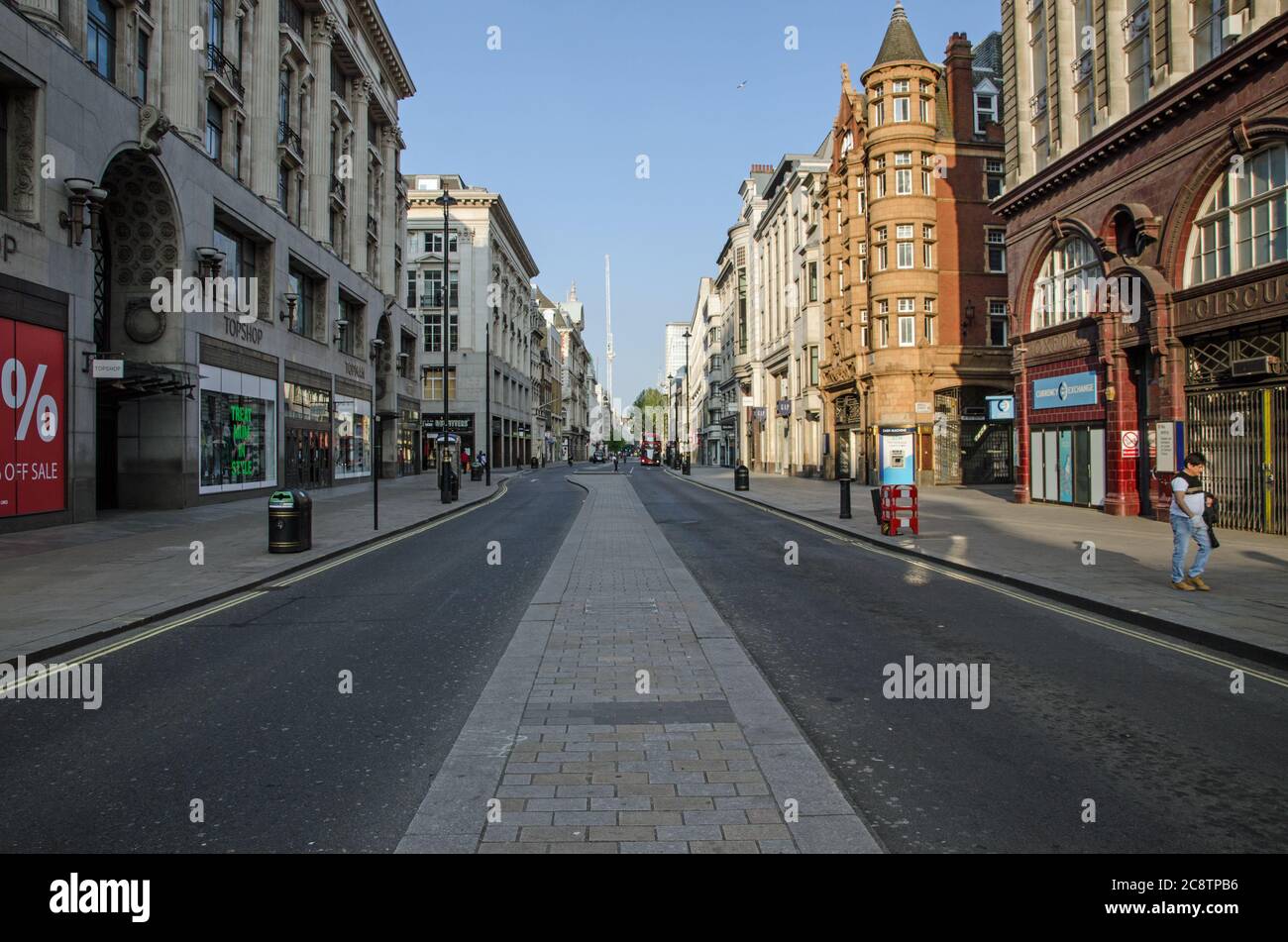 Londres, Reino Unido - 24 de abril de 2020: Una calle Oxford casi desierta en una soleada tarde de primavera durante el cierre de COVID19. Solo unos pocos peatones y veh Foto de stock