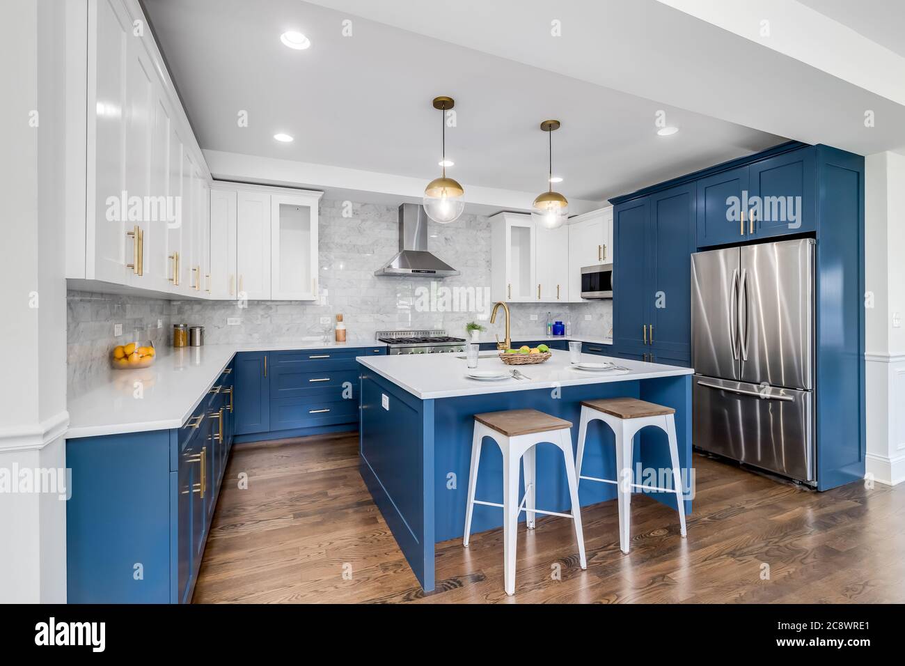 Una lujosa cocina blanca y azul con hardware dorado, electrodomésticos de  acero inoxidable Bosch y Samsung, y encimeras de granito de mármol blanco  Fotografía de stock - Alamy