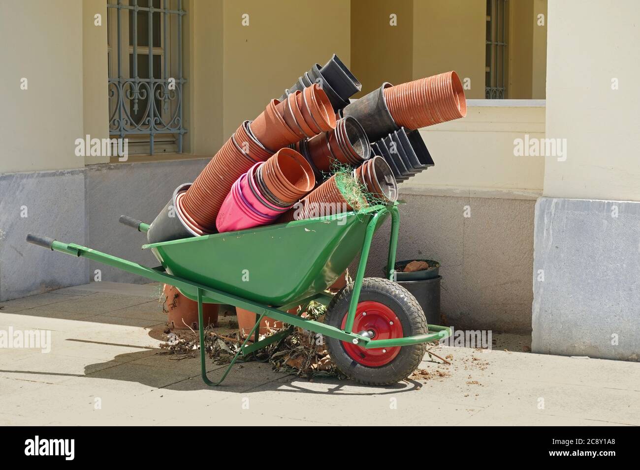 Carro de carretilla de jardín con macetas de flores vacías. Equipo de jardinería. Foto de stock