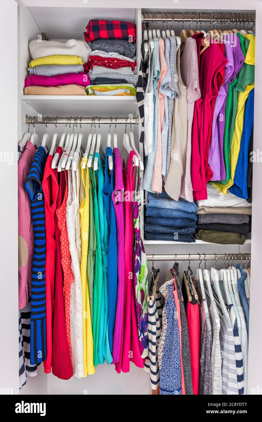 Armario de casa organizado vestidor de mujeres ropa de moda colgando en los  estantes. Estilo veraniego, vestidos y camisetas Fotografía de stock - Alamy