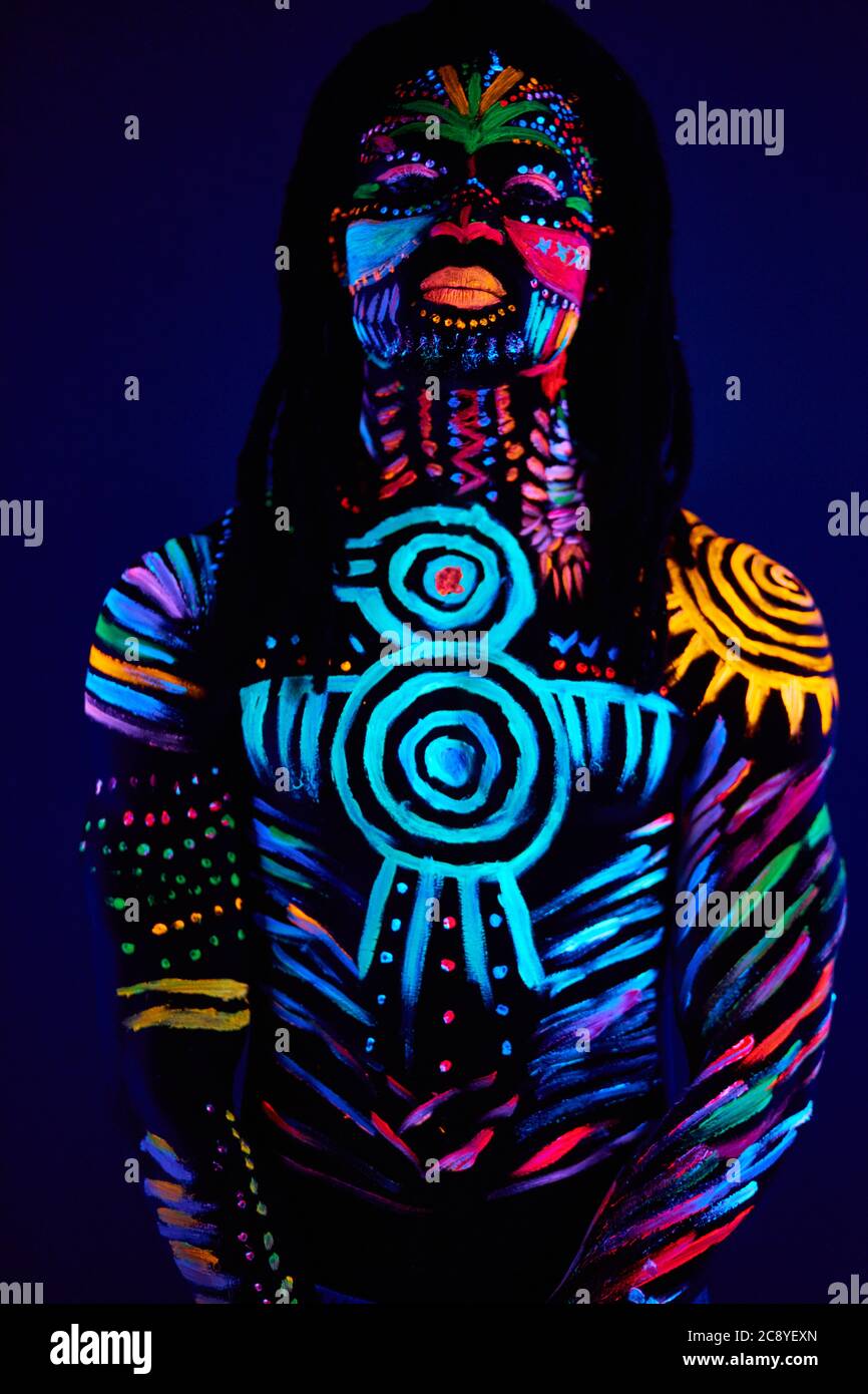 retrato de hombre africano pintado en pintura fluorescente en la cara y  torso muscular sin shirless, disparo de estudio con luz UV Fotografía de  stock - Alamy