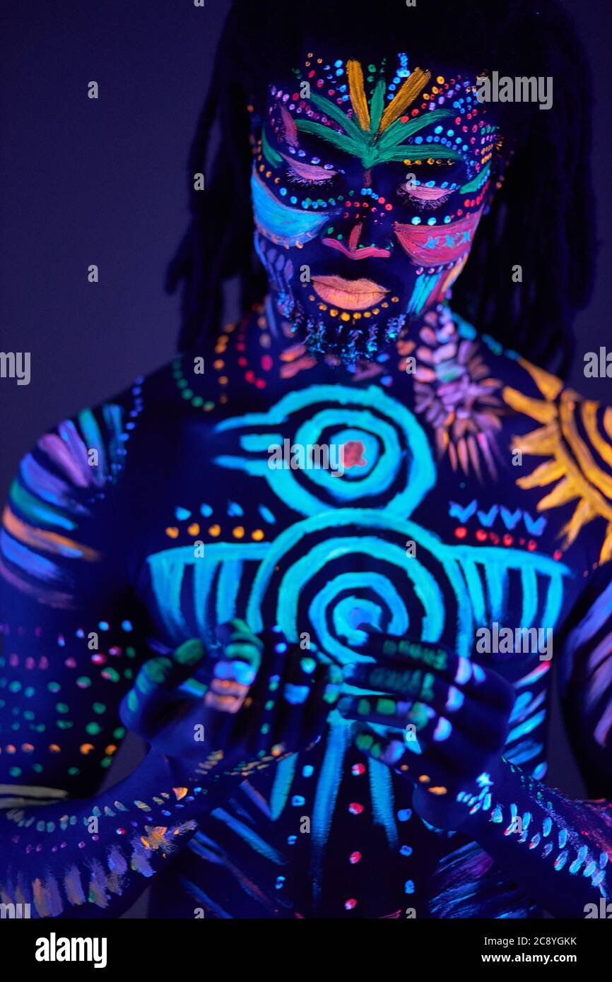 retrato de hombre africano con patrón étnico, maquillaje de neón en luz  ultravioleta. pinturas fluorescentes, grabados luminiscentes. diseño de  arte corporal de hombre posando Fotografía de stock - Alamy