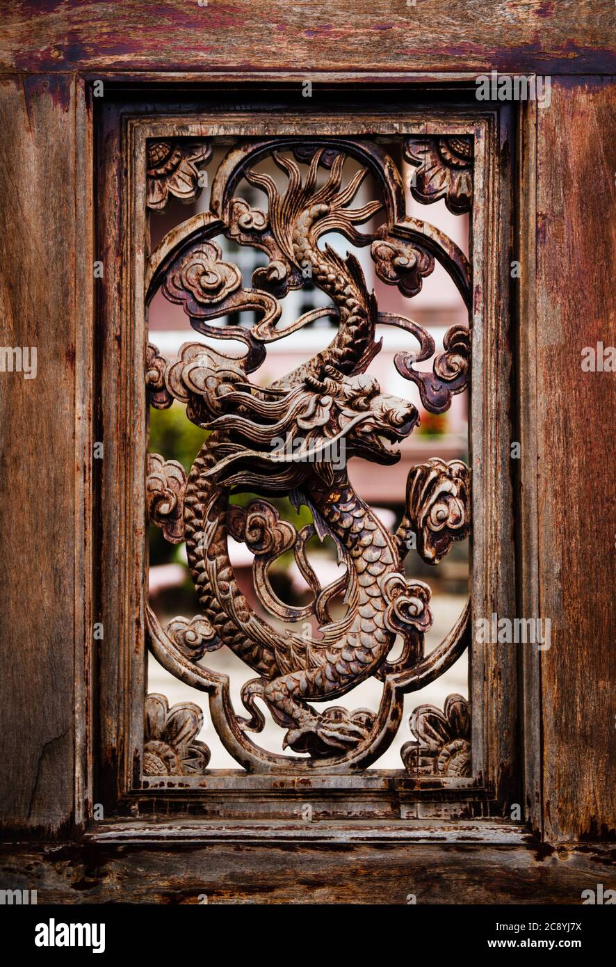 Tallado detallado de un dragón en una puerta de madera, Vietnam, Sudeste de Asia Foto de stock