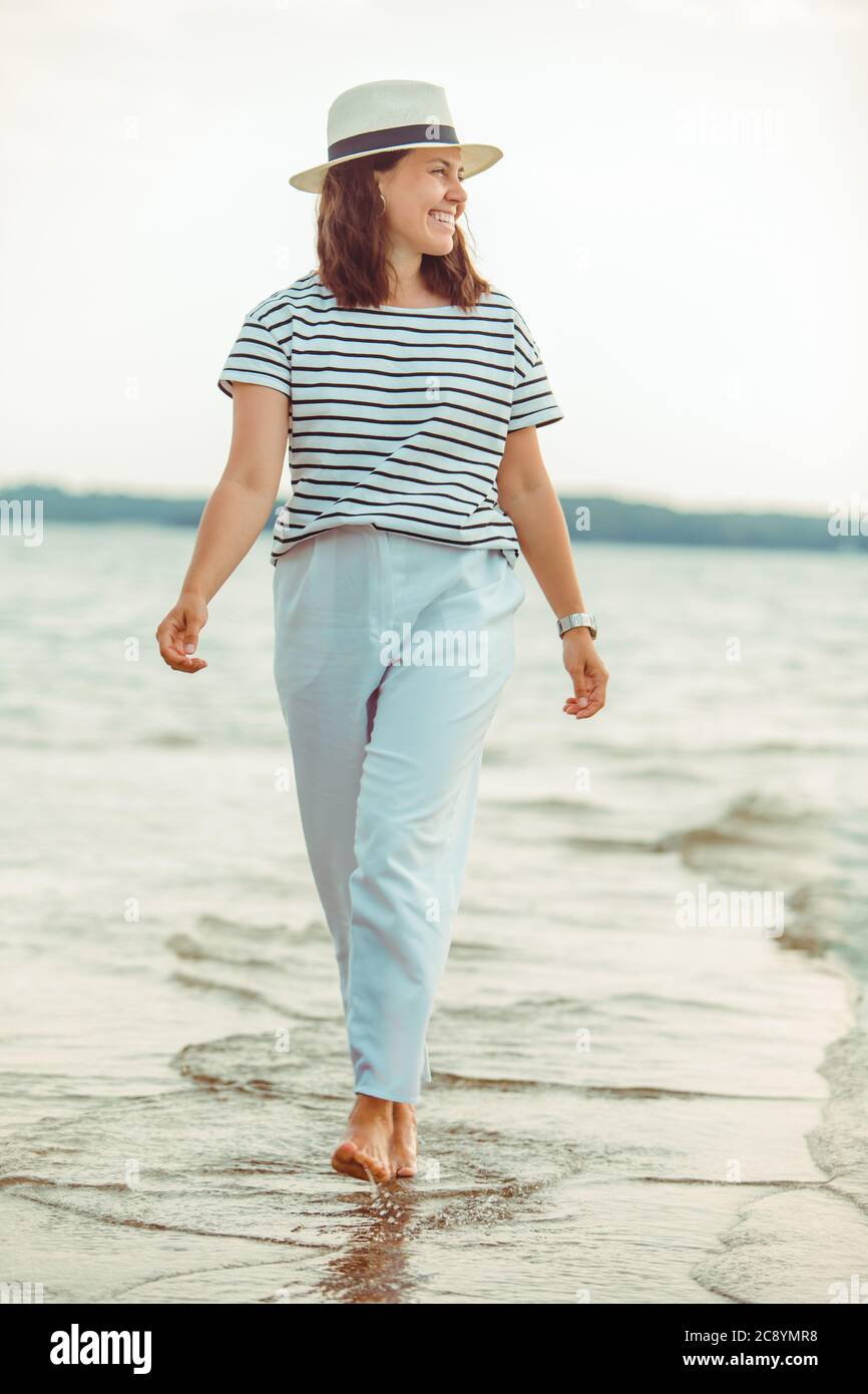 Mujer en ropa blanca caminando por la playa de mar Fotografía de stock -  Alamy