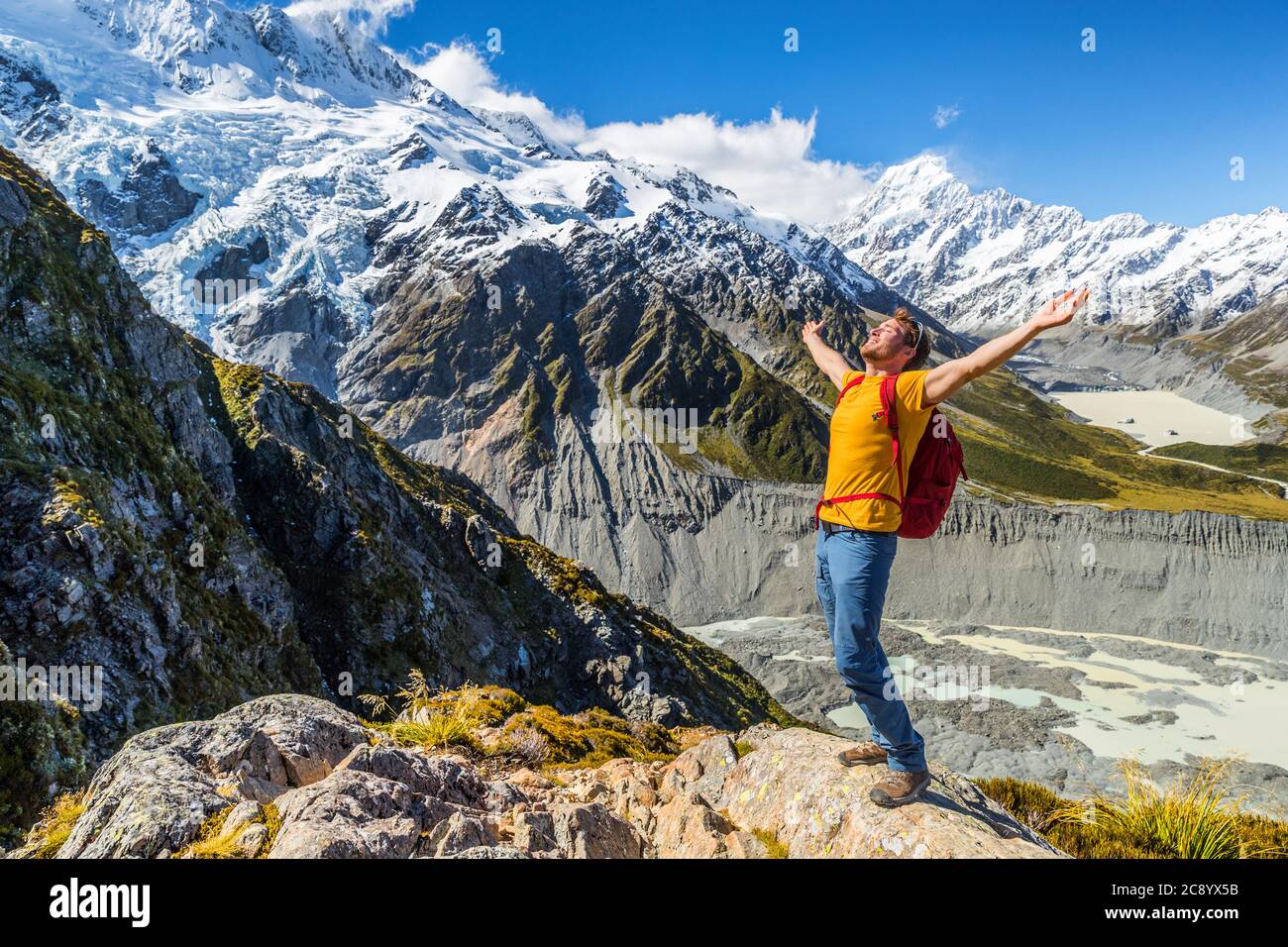 Nueva Zelanda éxito hiker hombre senderismo en Mount Cook. Animando a los turistas de aventura alcanzando el desafío de la meta en la cima de la ruta de la cumbre de montaña Foto de stock