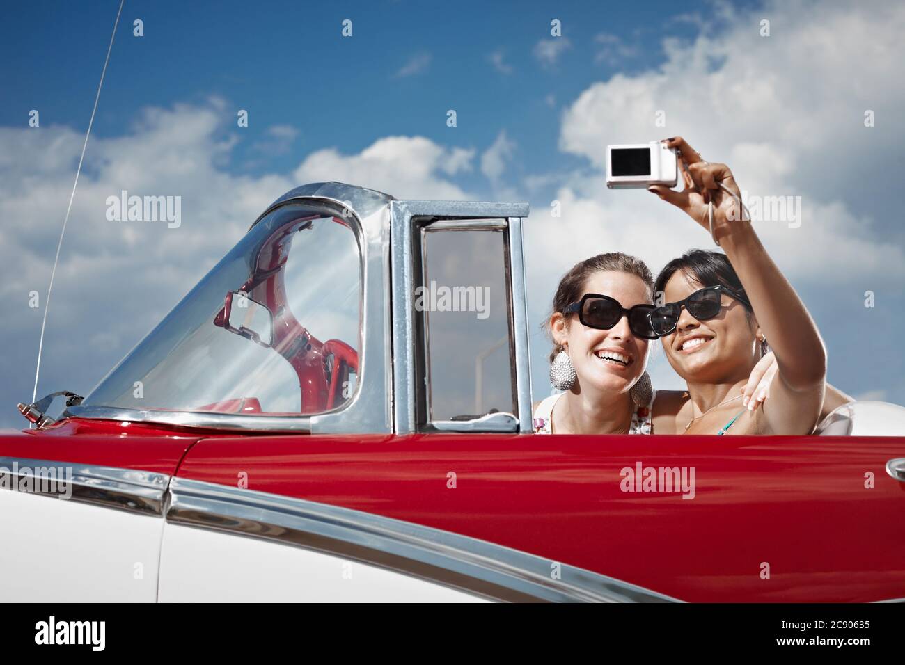 Feliz mujeres conduciendo coche convertible alquilado para vacaciones Foto de stock