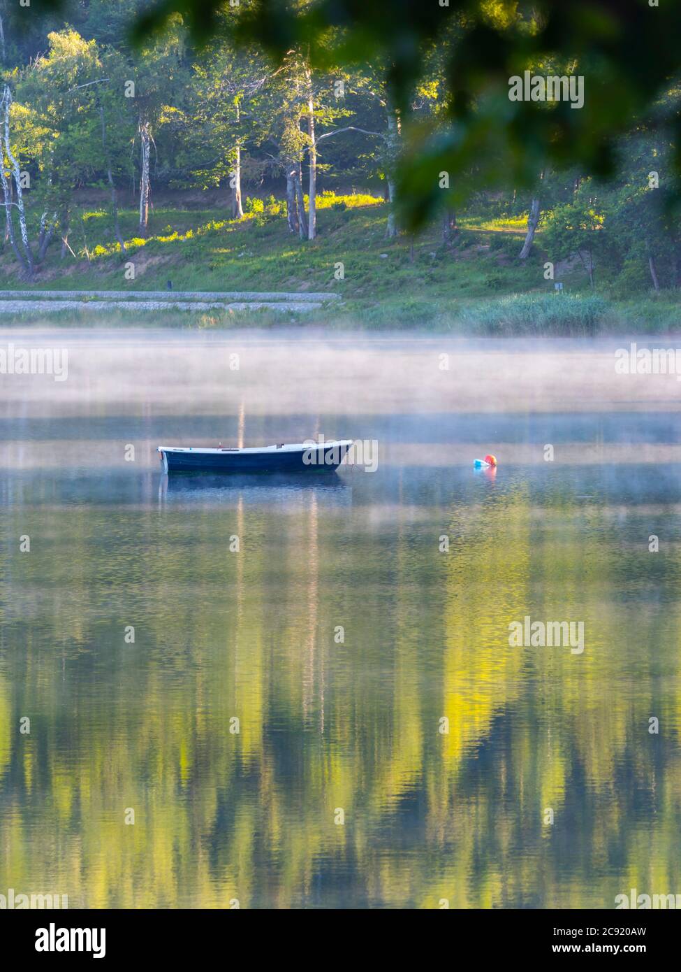 Lonesome barco en el lago Bajer en Fuzine Croacia Europa niebla vapor flotar flotar casi la superficie del agua Foto de stock