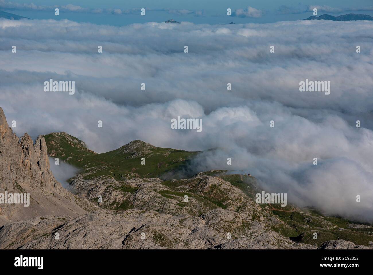 Mirando hacia abajo, desde la cima de una montaña, hasta la manta de nubes debajo. Foto de stock