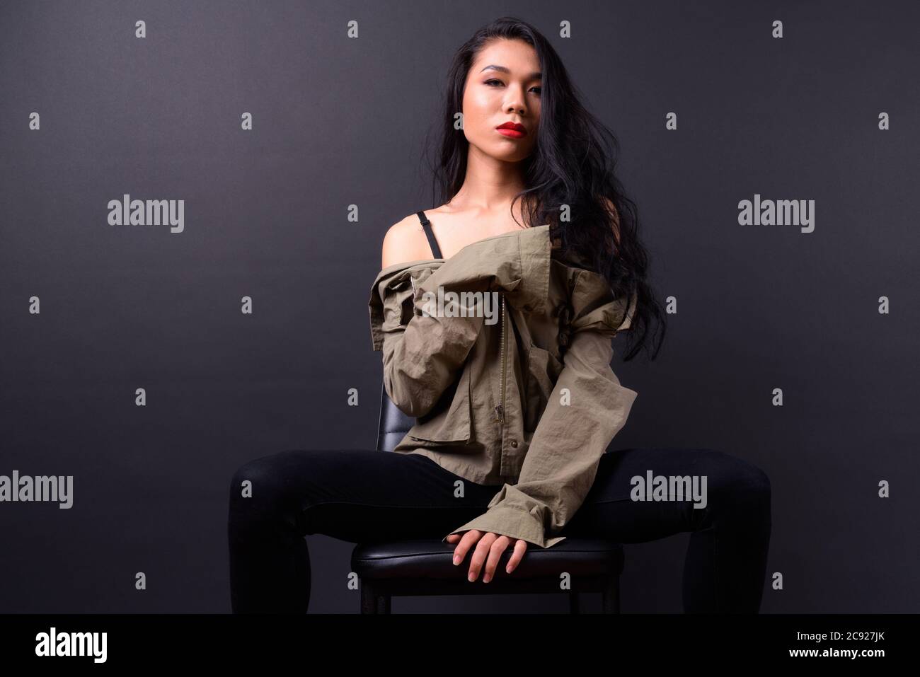 Joven hermosa mujer asiática transgénero contra fondo negro Foto de stock