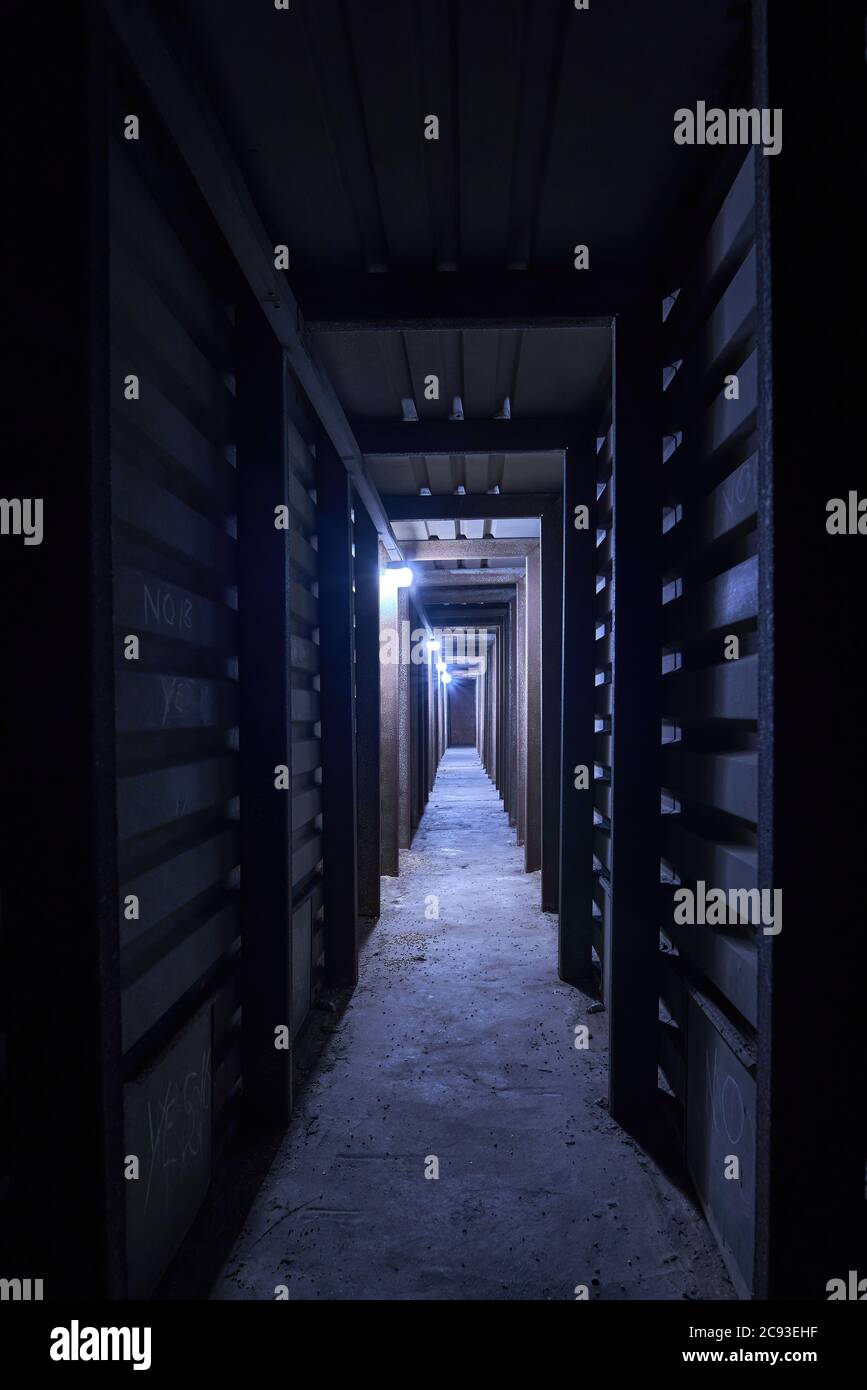 Túnel industrial de metal largo y oscuro opresivo o estructura de eje que conduce a la oscuridad parte de un secador de grano en la tienda Foto de stock