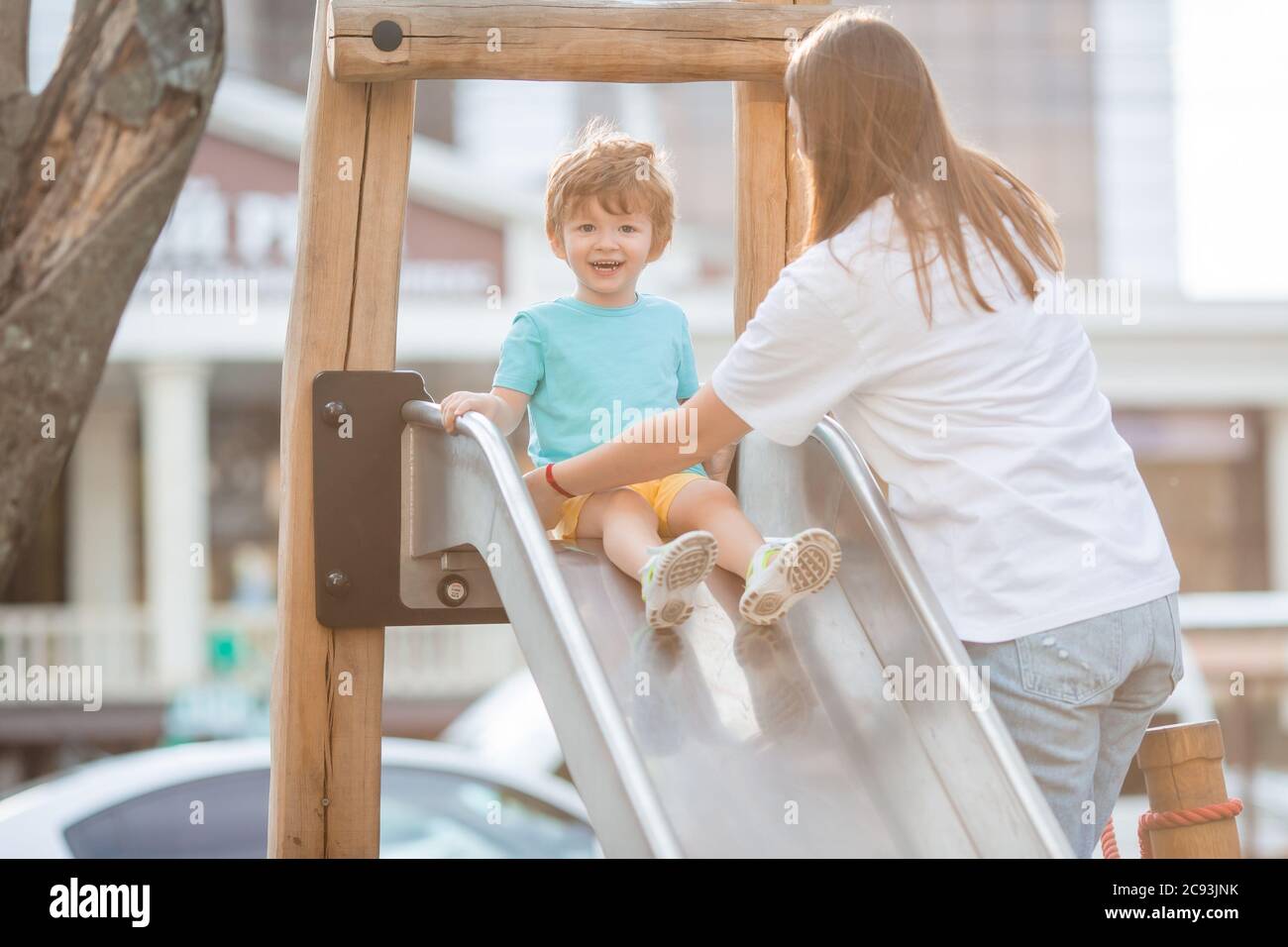 un niño de dos años juega en un pueblo para niños en el verano. Estilo de vida de los niños Foto de stock