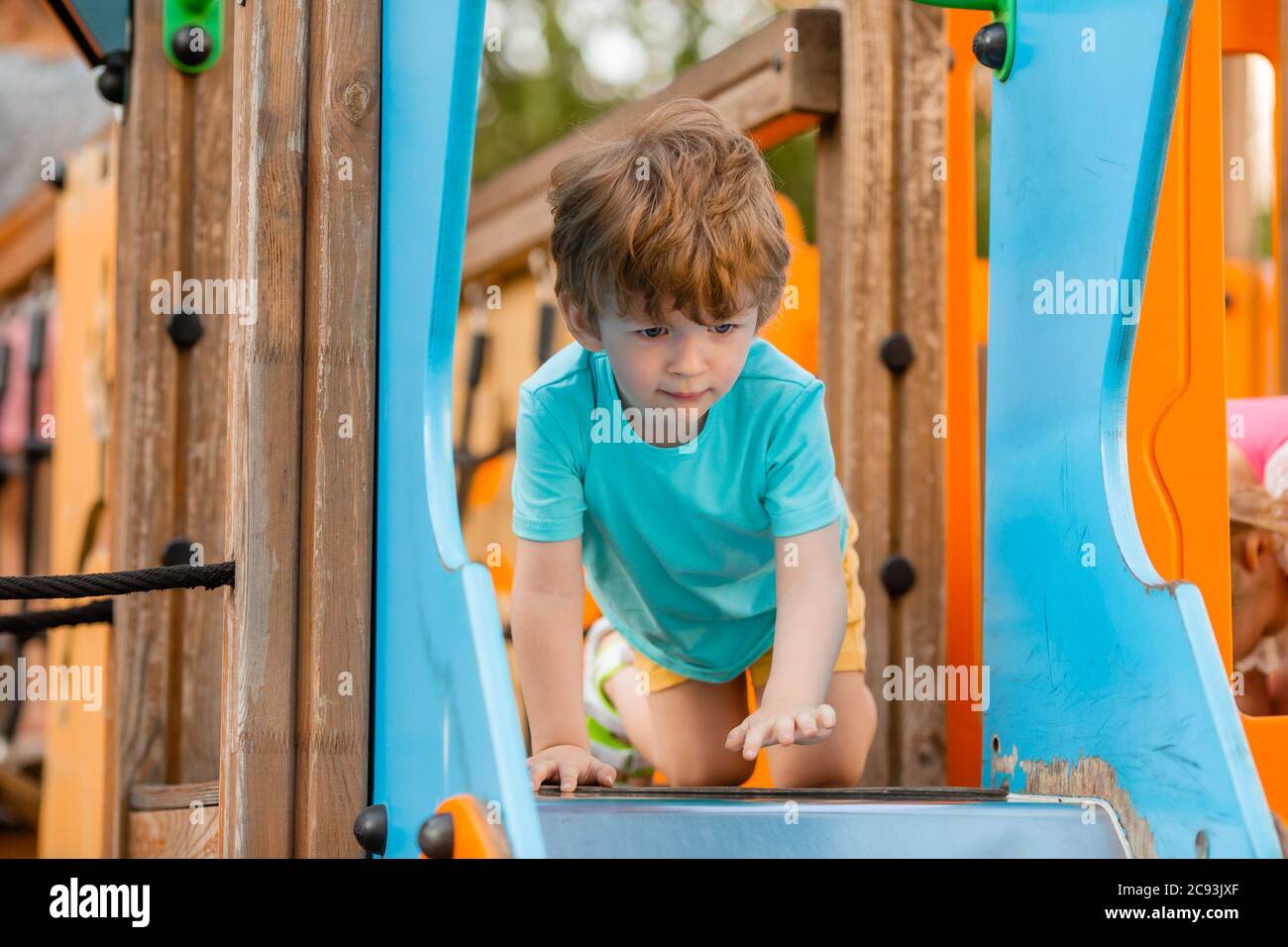 un niño de dos años juega en un pueblo para niños en el verano. Estilo de vida de los niños Foto de stock