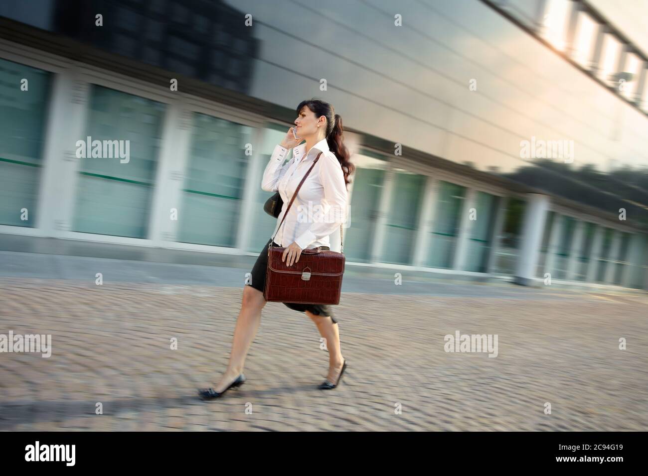 Mujer madura llegando tarde a la oficina caminando rápido en la calle Foto de stock