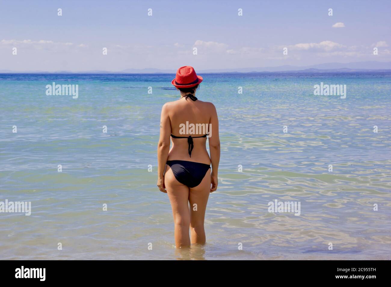 Una mujer sexy en bikini tanga caminando por la orilla de la playa en  pinedo valencia