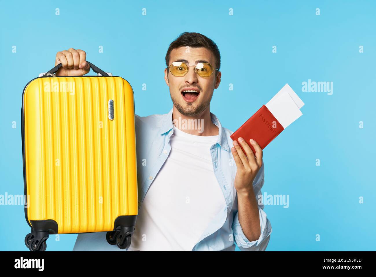 Pasaporte y billetes de avión equipaje maleta amarilla pasajero hombre con  gafas Fotografía de stock - Alamy