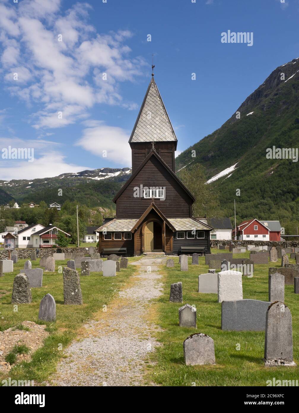 Røldal Stave Iglesia dic en un valle en el oeste de Noruega que data de CA 1250, exterior con cementerio y hermoso paisaje Foto de stock