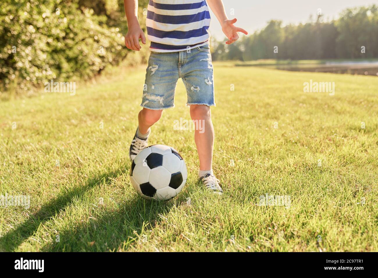 Niño jugando al fútbol en la hierba Foto de stock