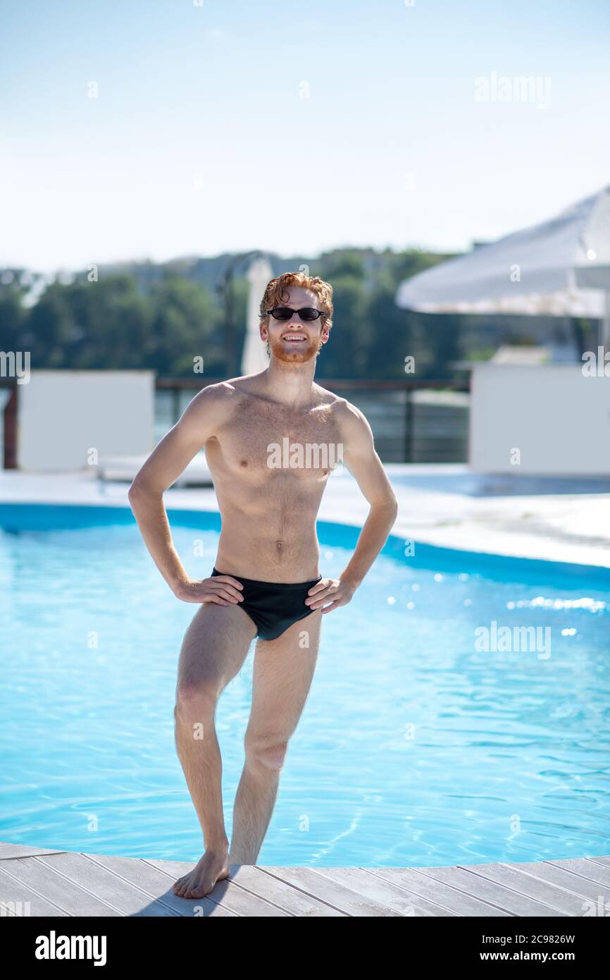 Hombre muscular en traje de de pie cerca de la piscina Fotografía de stock - Alamy