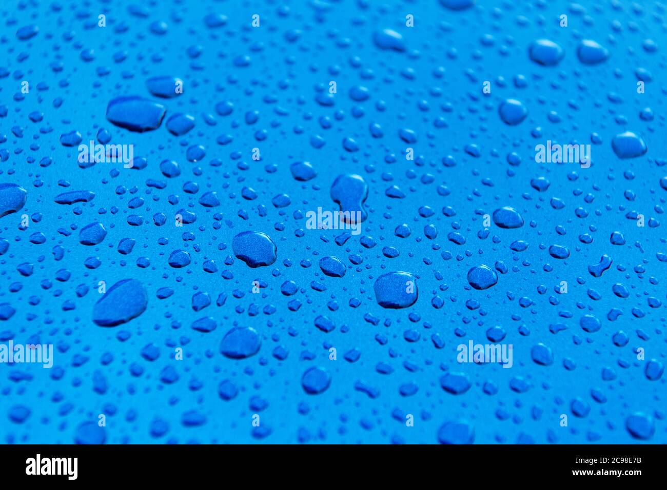 Tema de la industria automotriz. Cuerpo de coche azul cubierto por el lavado de coches gotas de agua de cerca. Foto de stock