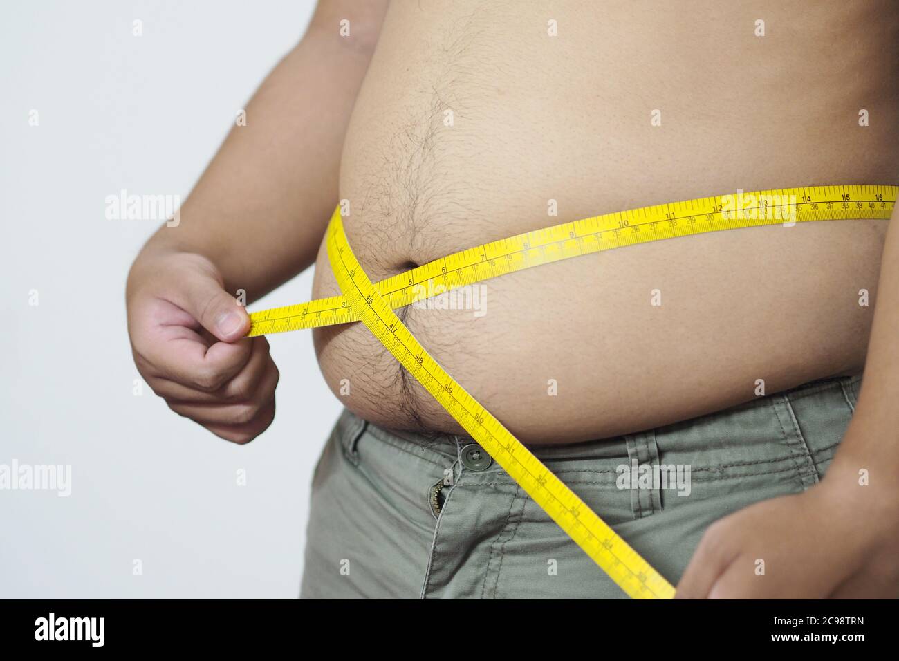 Hombre gordo sosteniendo una cinta métrica plástica para calcular la grasa  corporal Fotografía de stock - Alamy