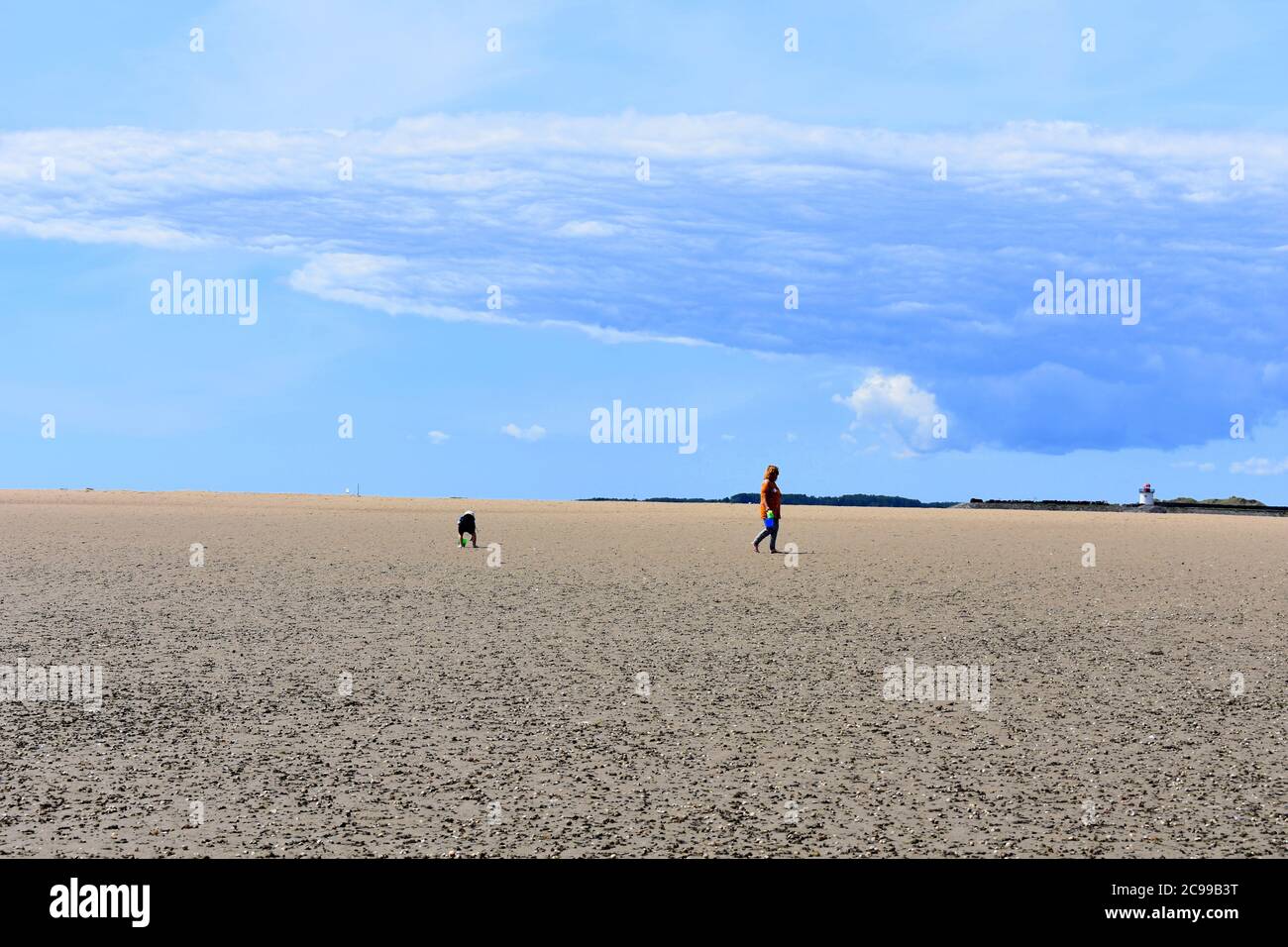 Mujer y niño en la playa de Burry Port East en marea baja, Burry Port, Carmarthenshire, Gales Foto de stock