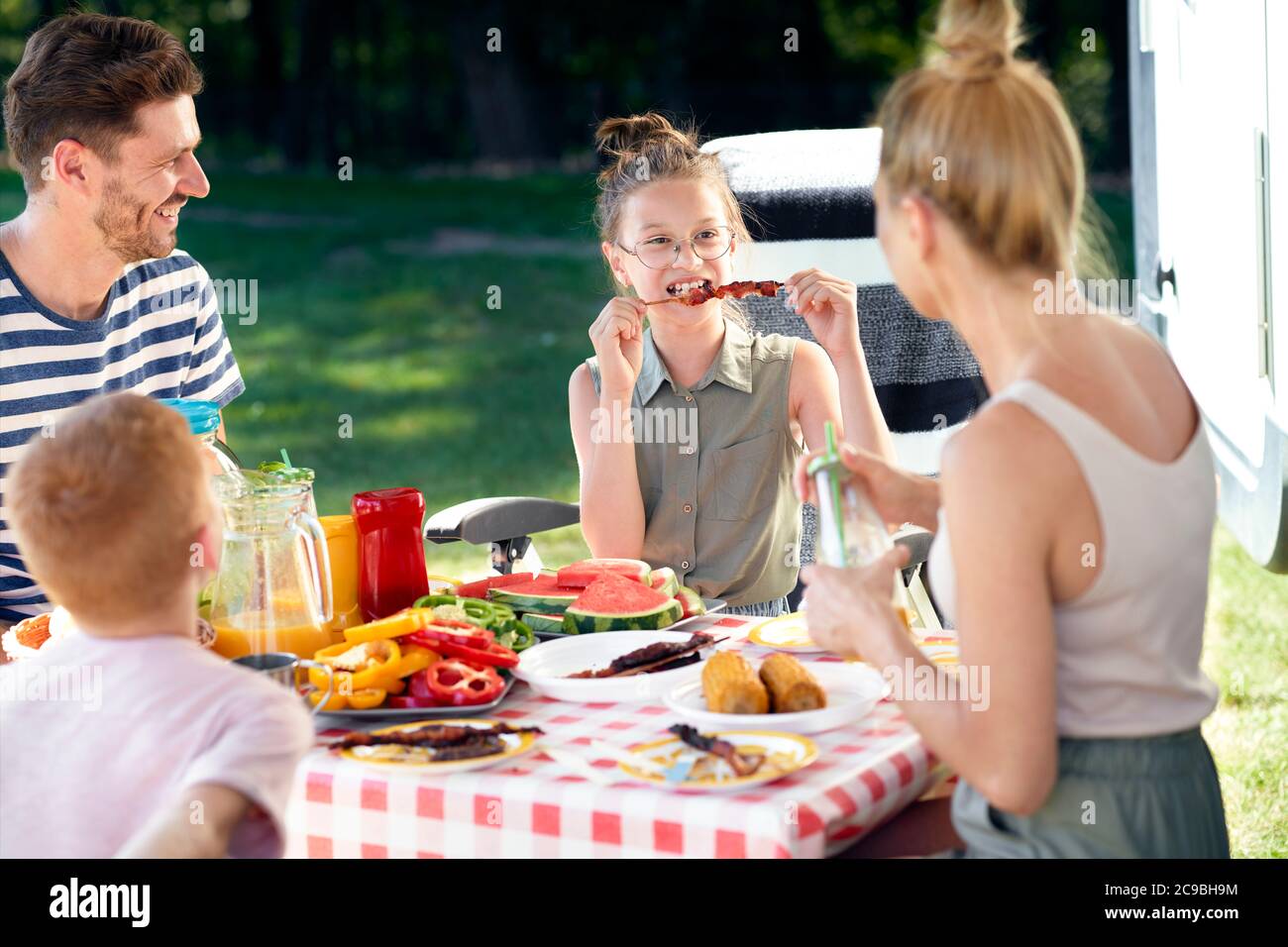 Familia disfrutando de un almuerzo en el picnic del campista Foto de stock