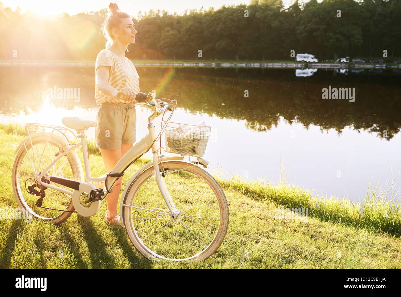 Mujer con bicicleta junto al lago Foto de stock